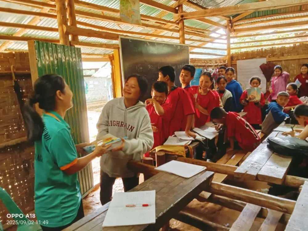 Students and teachers with the pens, notebooks and other supplies distributed to their school by HFA and BCMF.